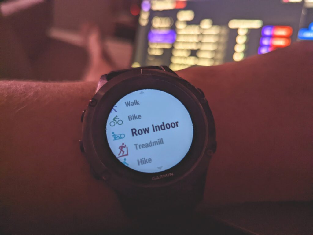 Low light Garmin Fenix 5 shows the Row Indoor option with the backlight on.