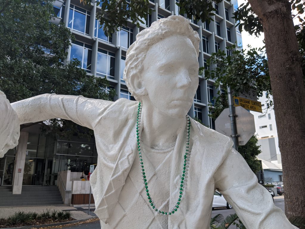 Close-up of the male danxer. The statue is completely white, it's a very rough texture, the eyes are empty and white.