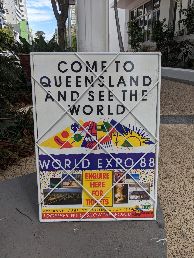 A newsstand next to the artwork reads "Come to Queensland and see the world, World Expo 88. Enquire here for tickets. Together we'll show the world."