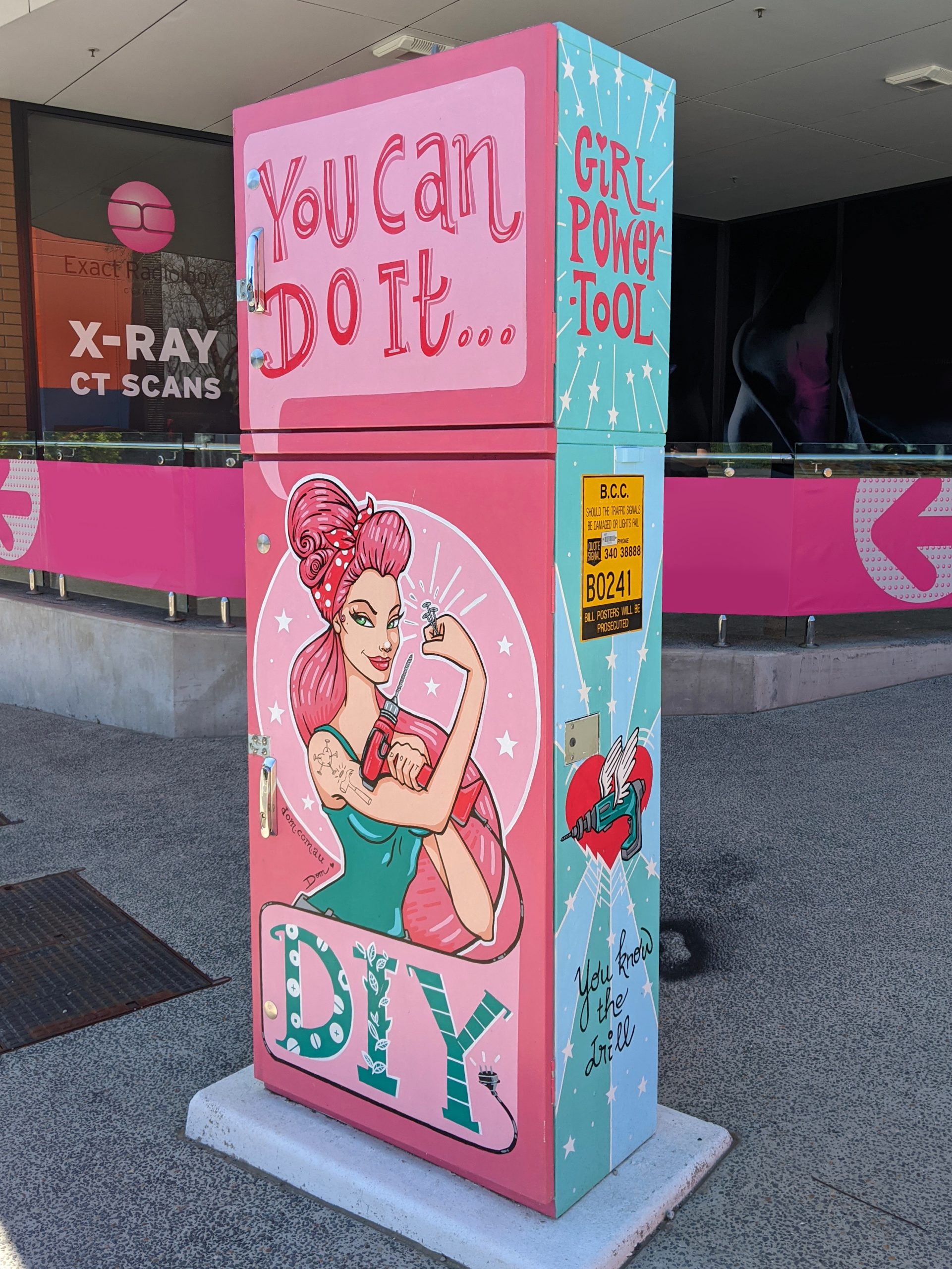 A bright pink and blue traffic signal box reads "you can do it"