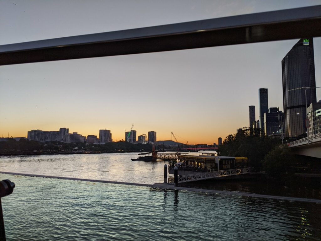 A cloudless sky looking along the Brisbane river at Southbank and the ferry stop on the north side.