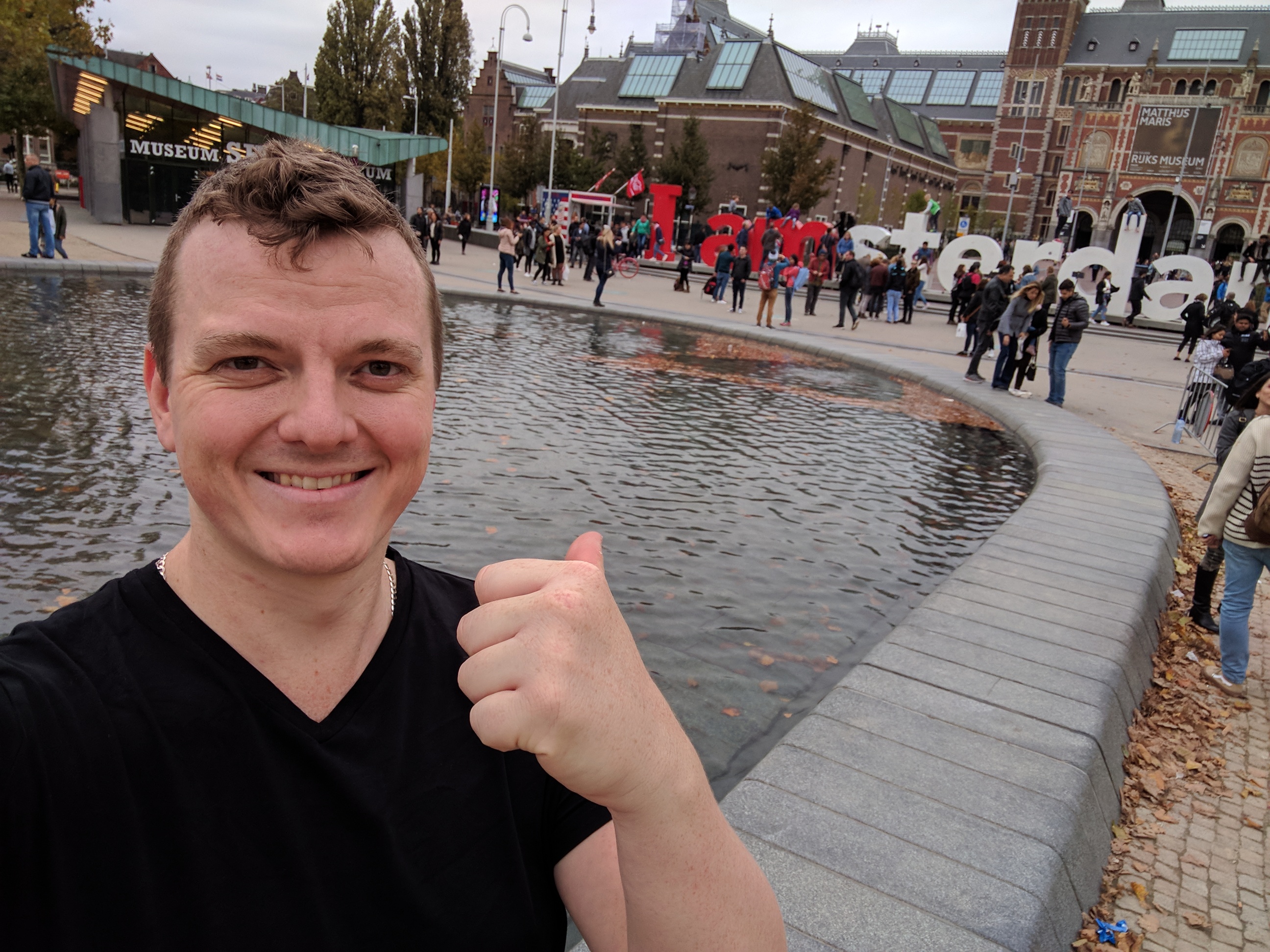 Me in front of a pond in front of the I Amsterdam sign in front of the Rijks Museum. There's people everywhere.