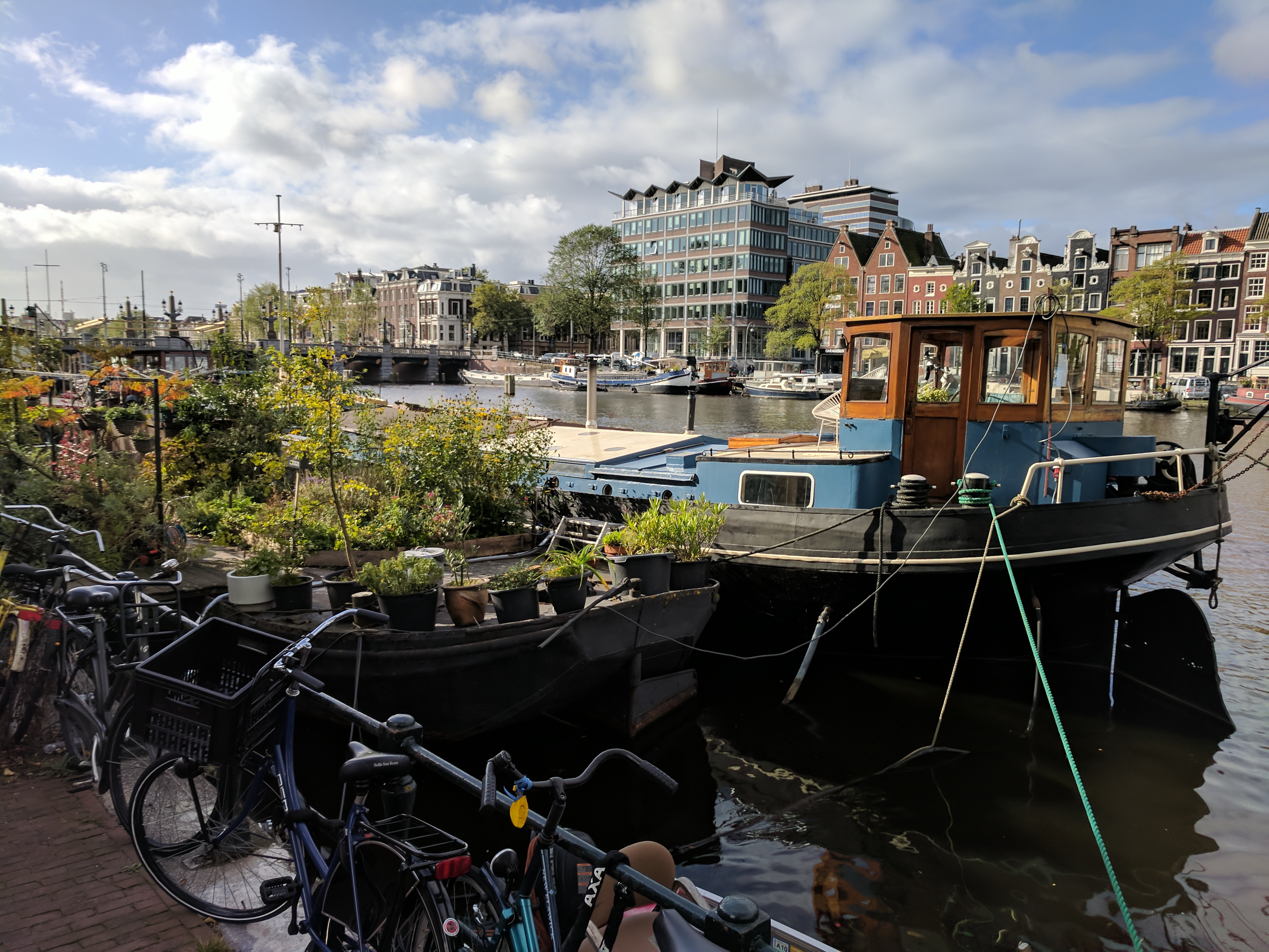 A houseboat with a garden moored along the River Amstel.