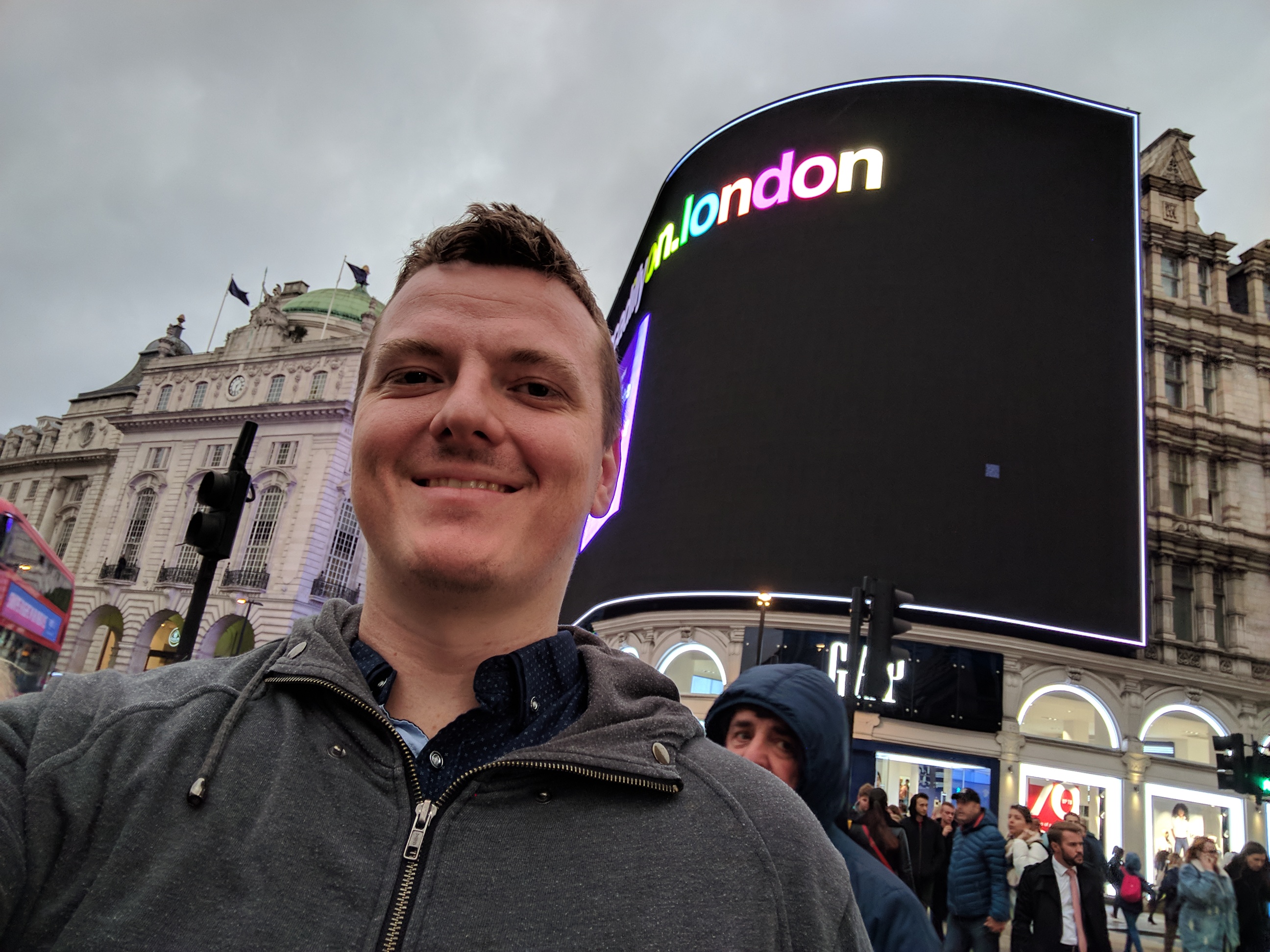 Me smiling in front of the most MASSIVE billboard with "london" written in rainbow text.