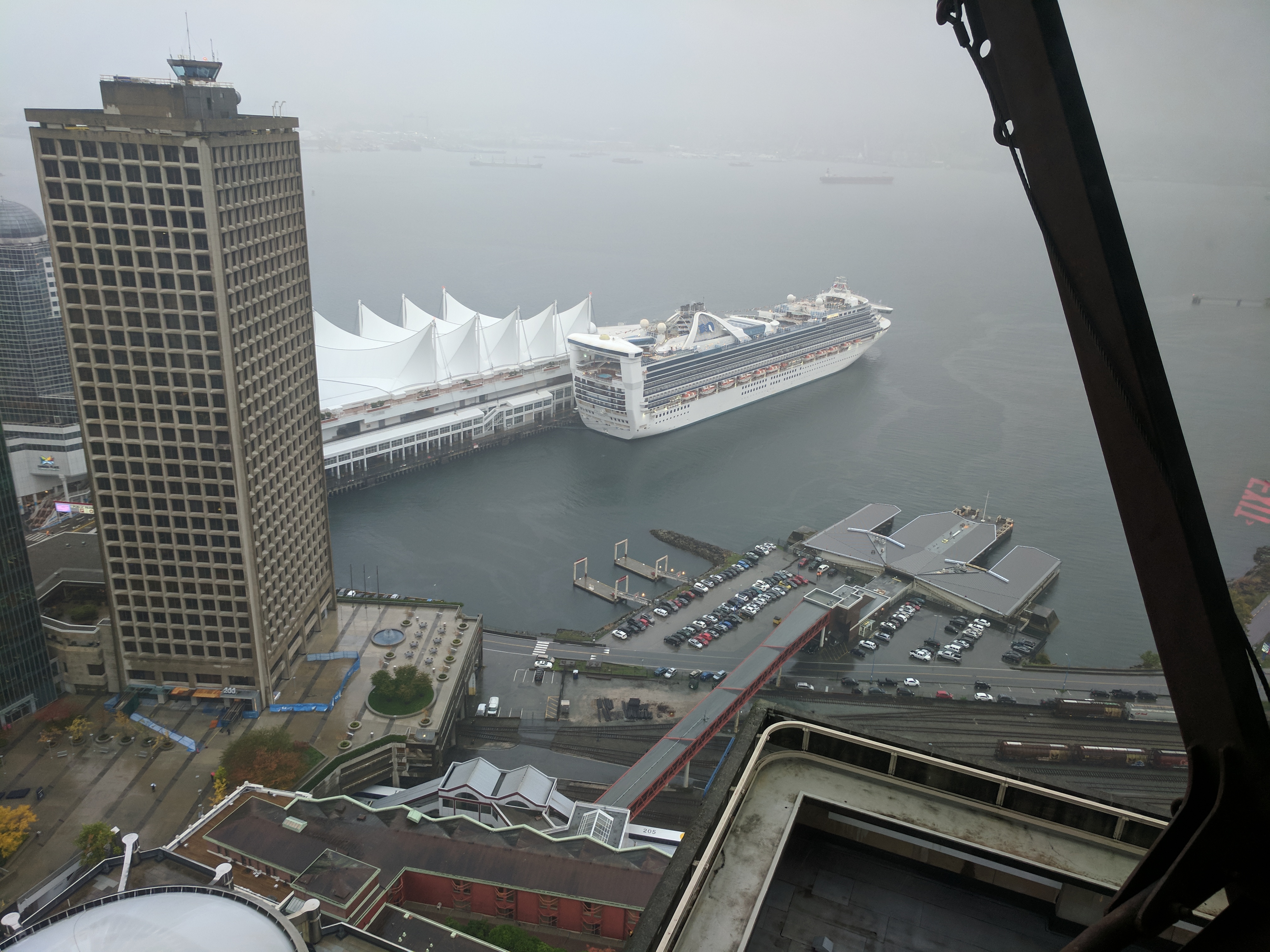 Looking down from an observation tower at a large cruise ship. It's miserable weather.