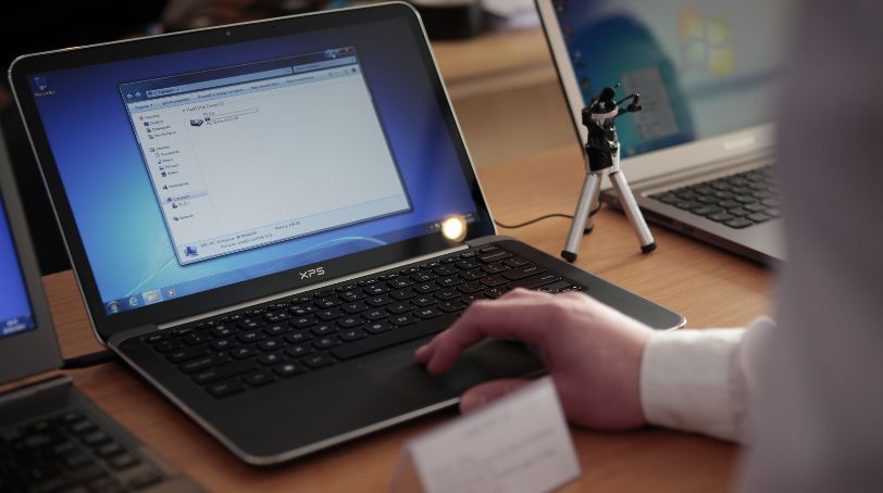 A person uses a the Dell XPS 13 at a display stand