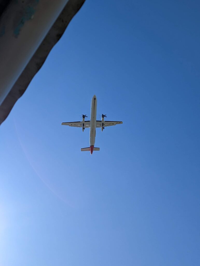 A propeller plane flies low overhead.